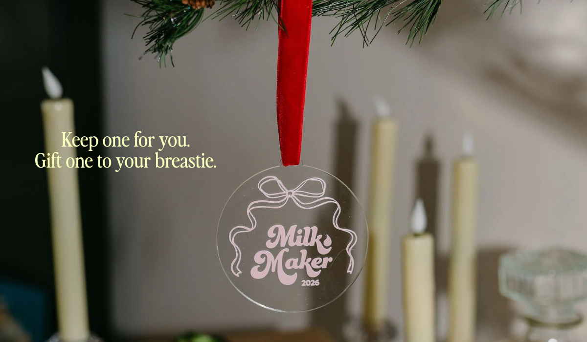 2026 Milk Maker Christmas ornament hanging from a pine garland with red velvet ribbon, keepsake gift for breastfeeding moms by The Little Milk Bar
